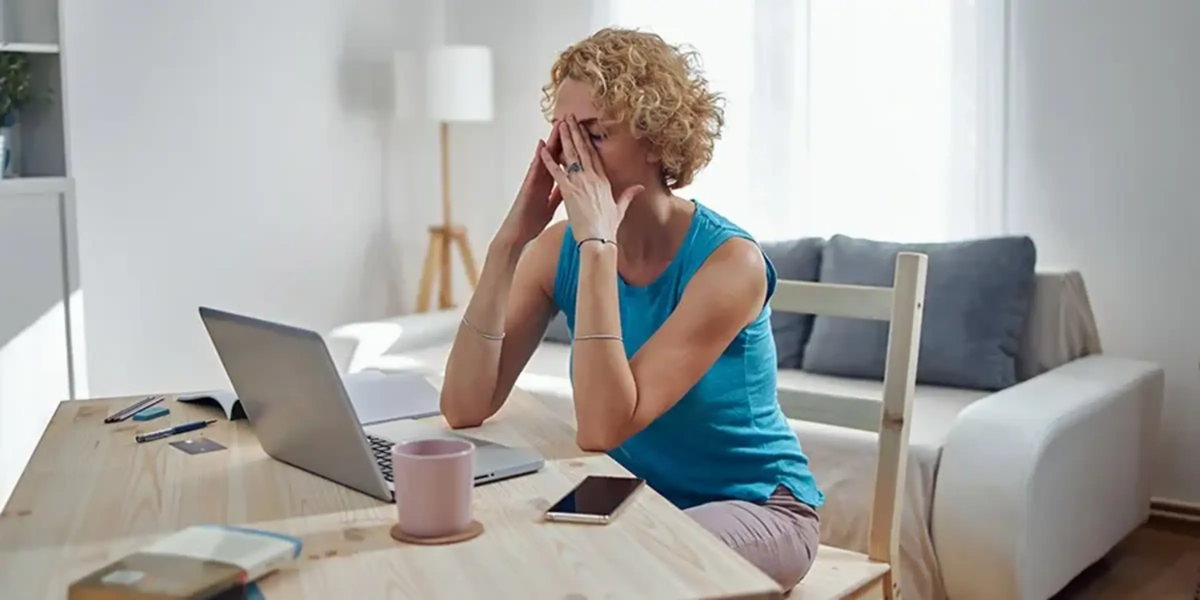 woman holding head from migraine pain