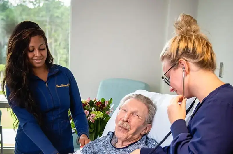 two nurses assisting patient