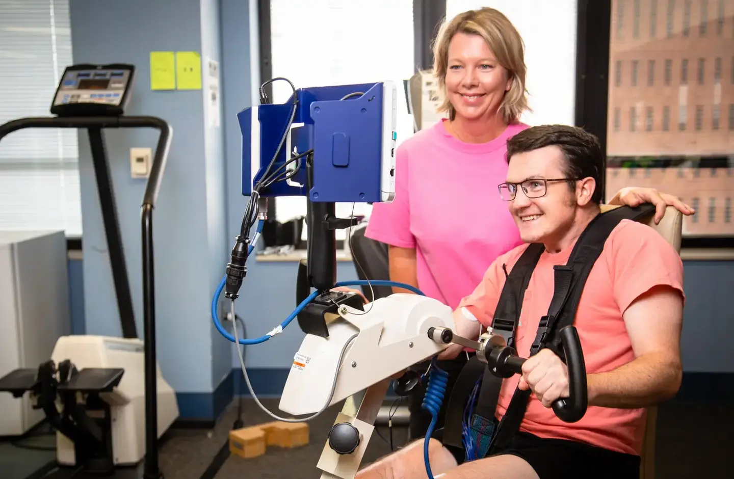 therapist helps patient use equipment
