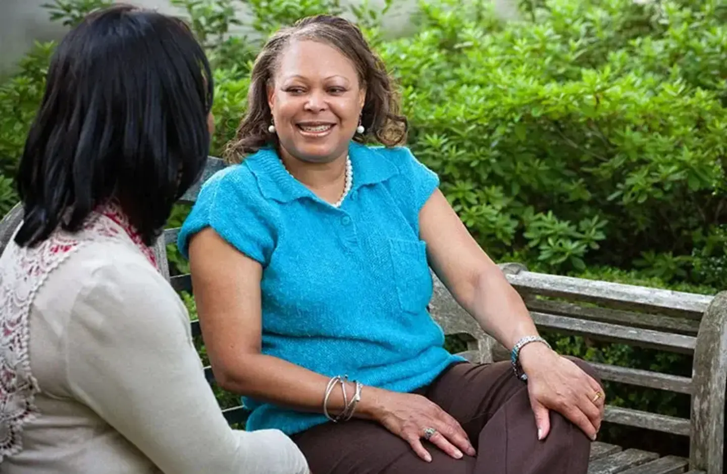 women sitting on park bench