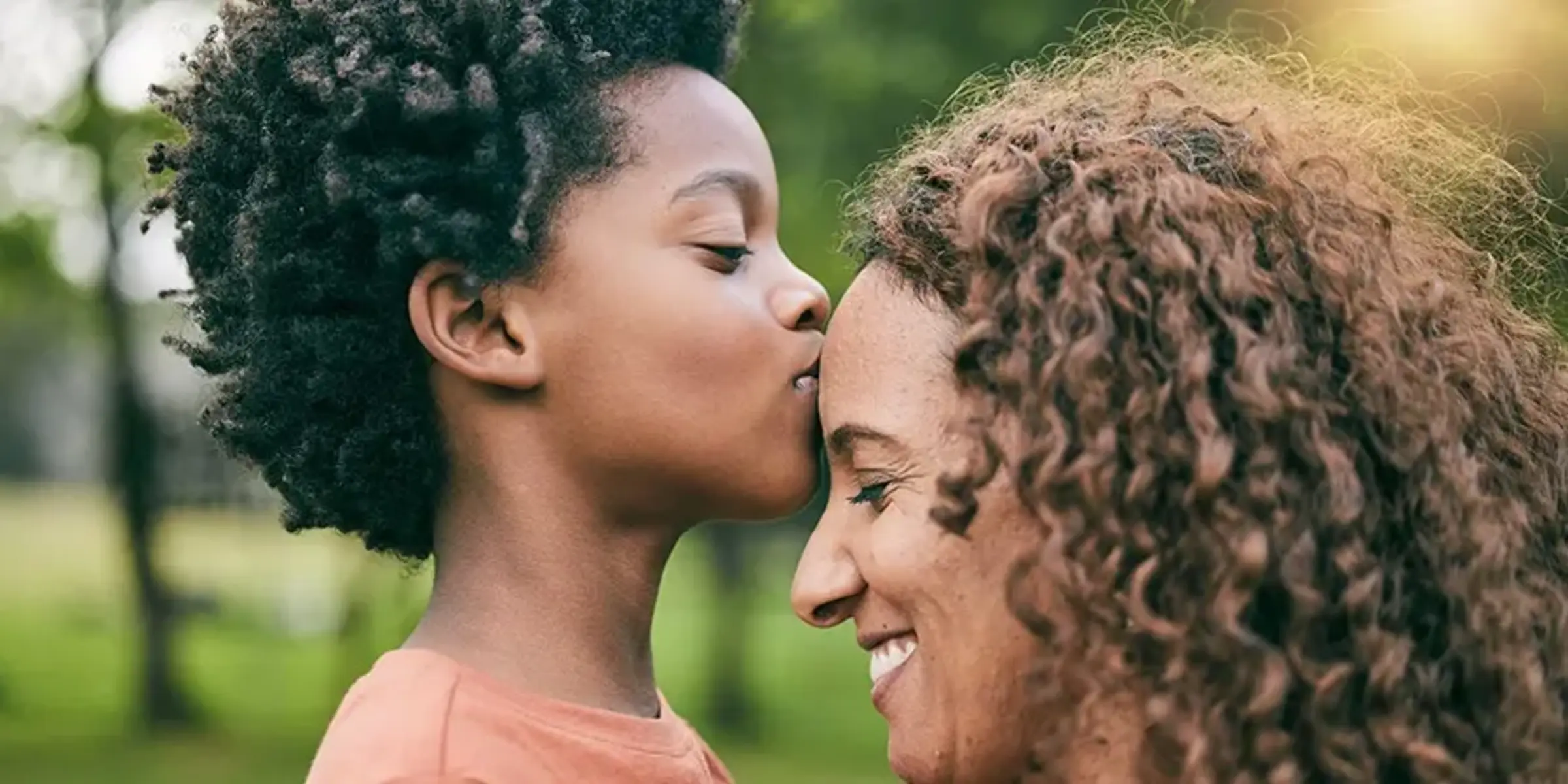 Boy kissing mother on forehead