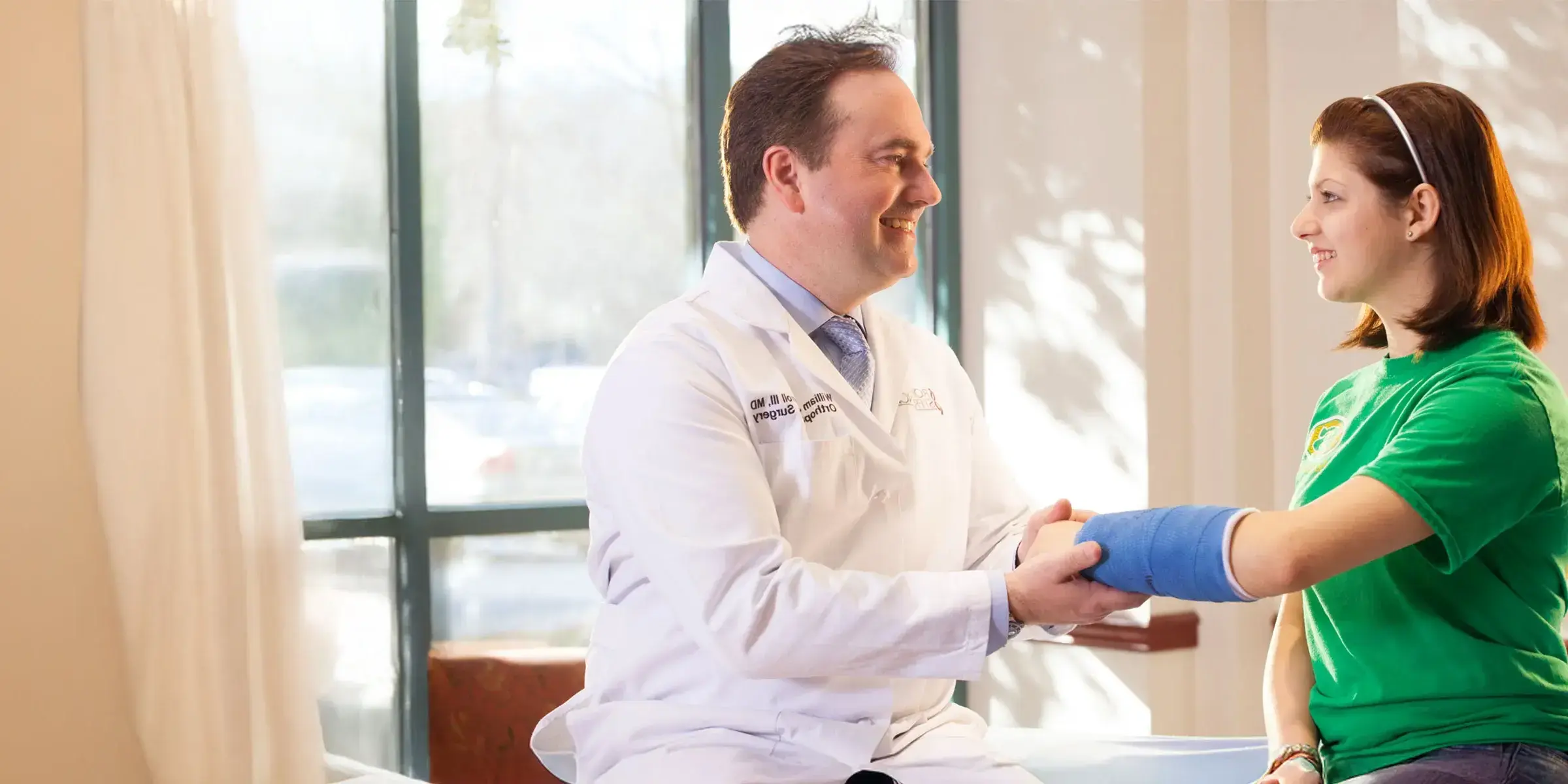 Doctor checking a child's cast on a broken arm