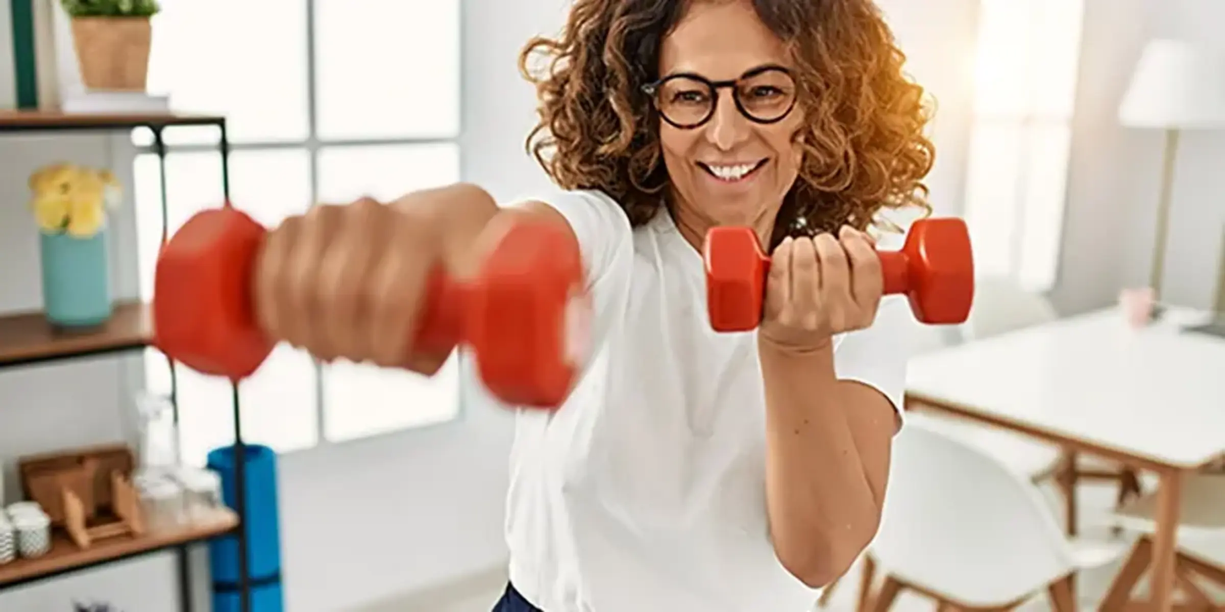 Middle age hispanic woman training using dumbbells