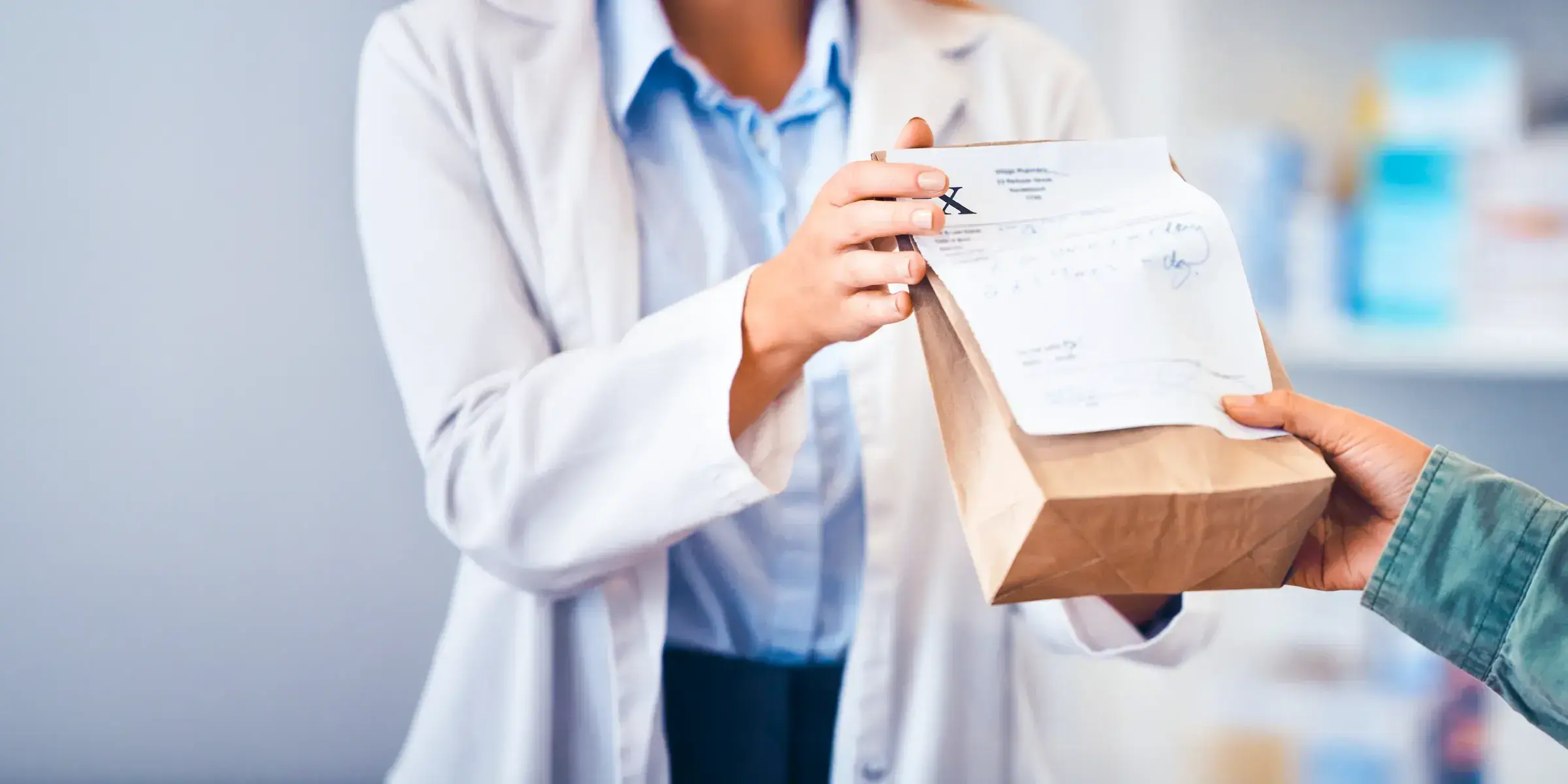 Pharmacist hands patient prescription