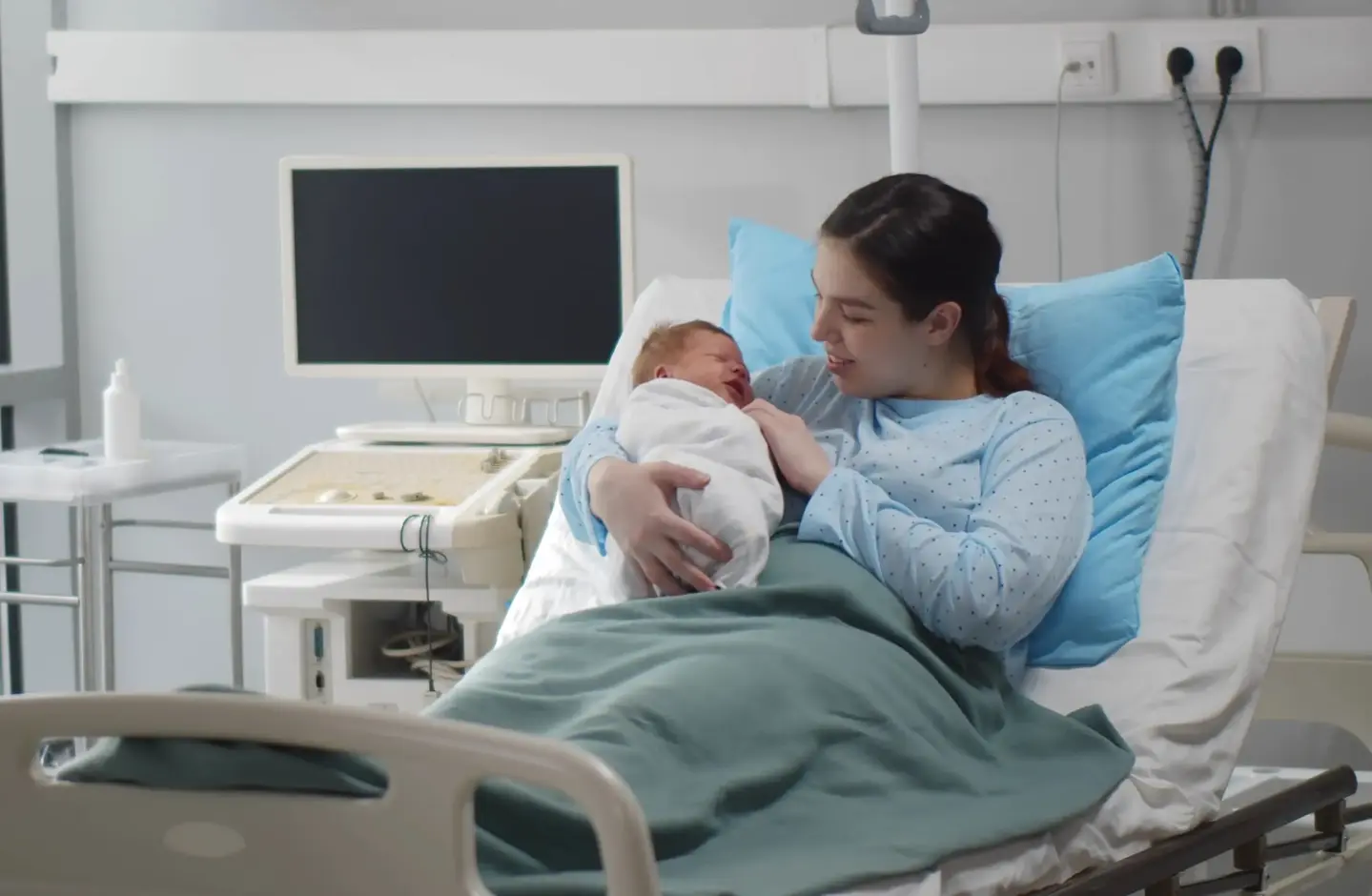 A happy mother holding her newborn baby in a Bon Secours St. Francis Hospital maternity suite.