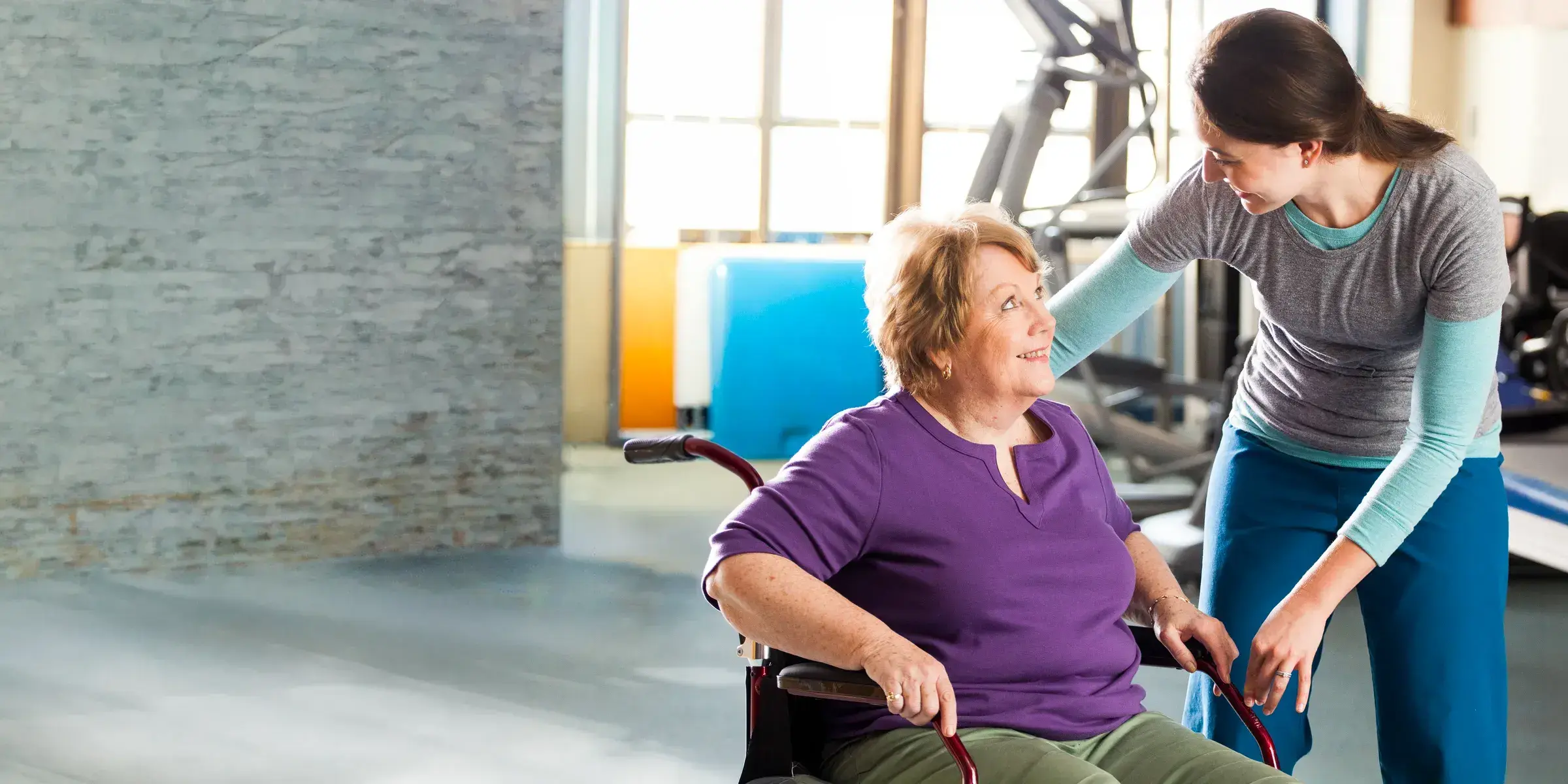 specialist helps patient in a wheelchair
