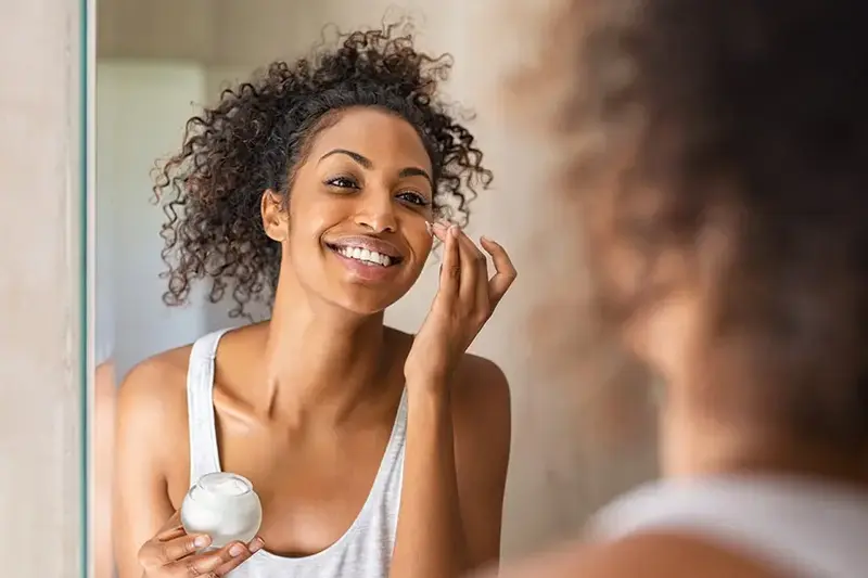 young girl moisturizing her skin