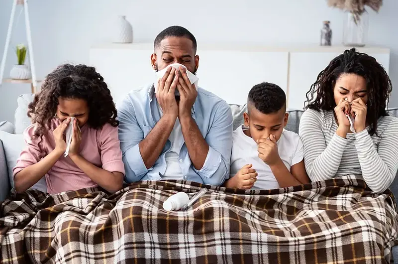 family sitting on the couch with the sniffles