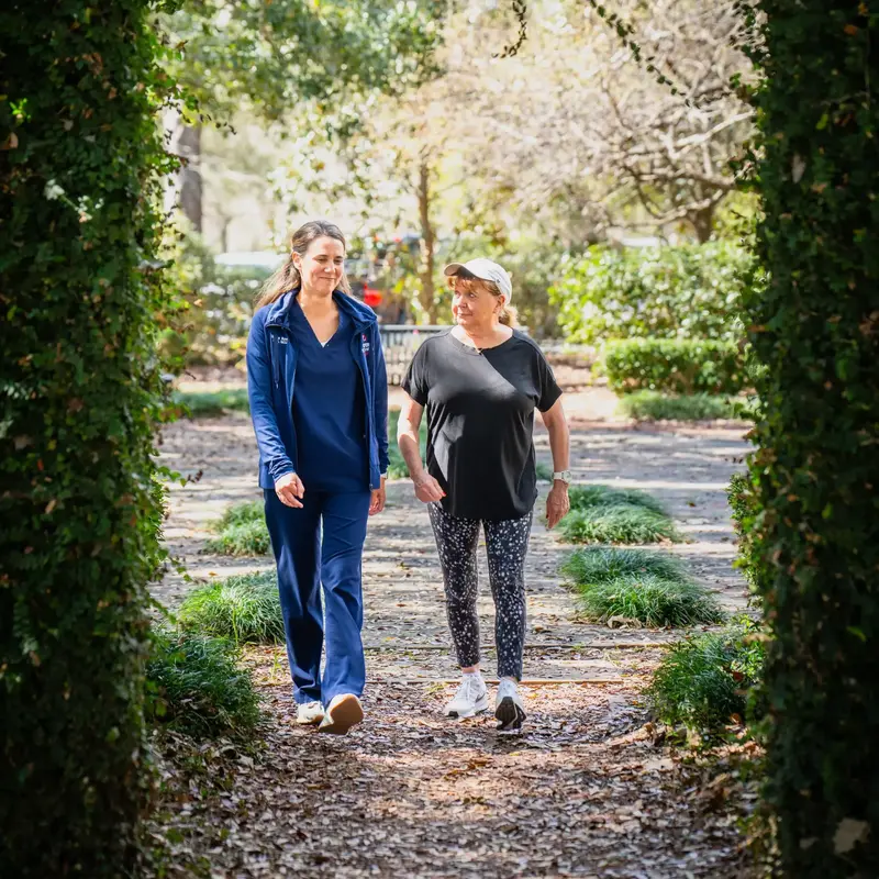 Patient and nurse walk in park