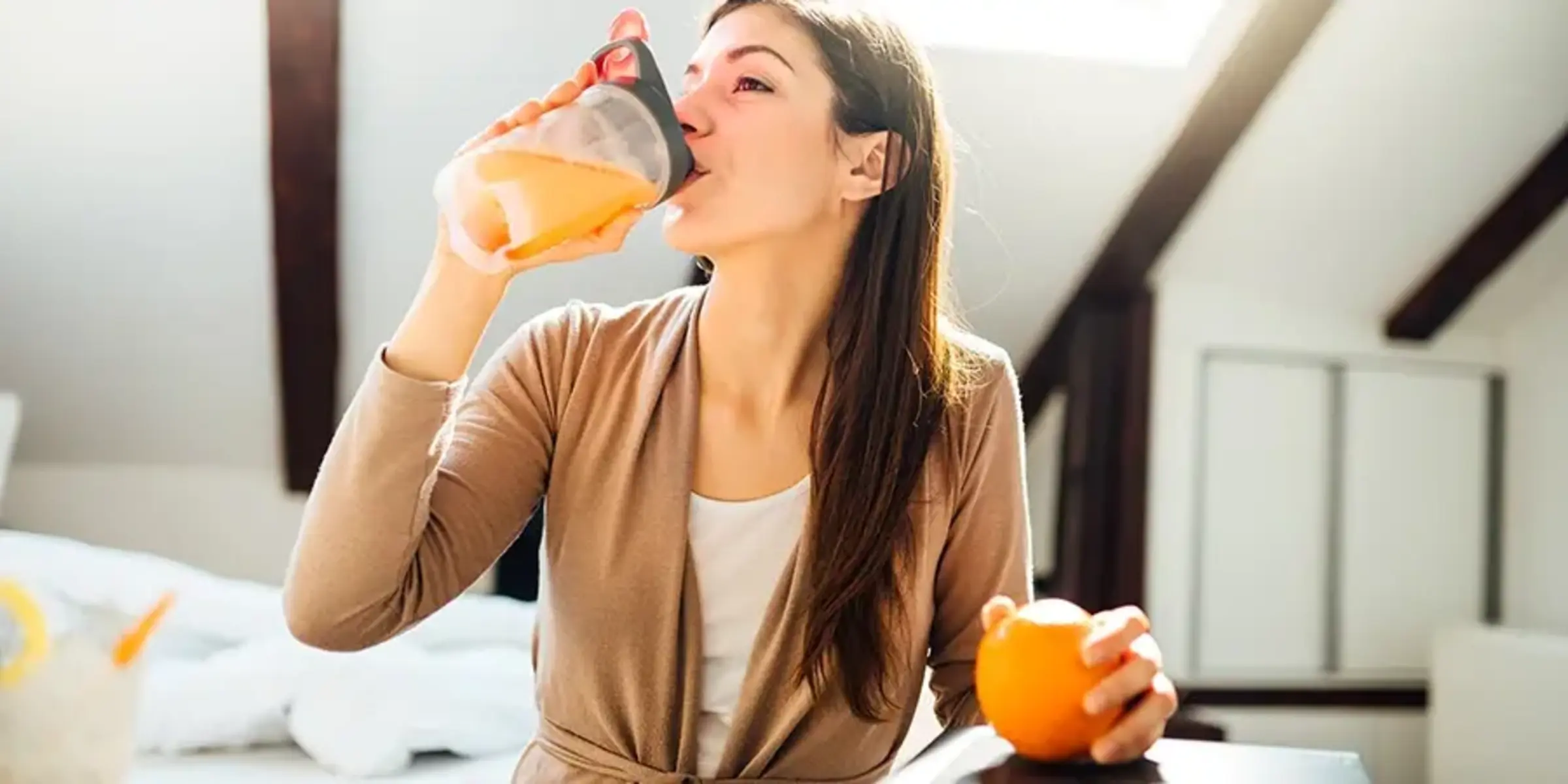 woman drinking orange juice in home office