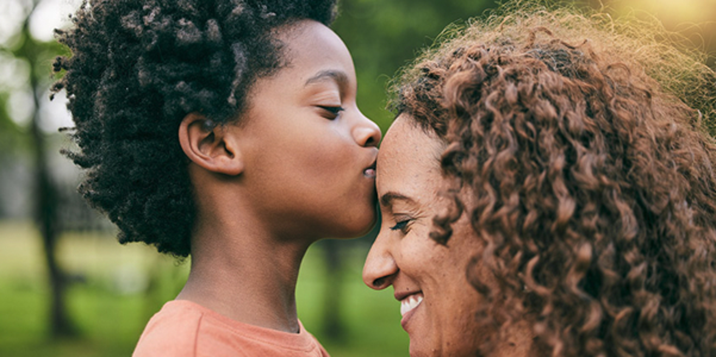 Photo of a child kissing his mother on the forehead