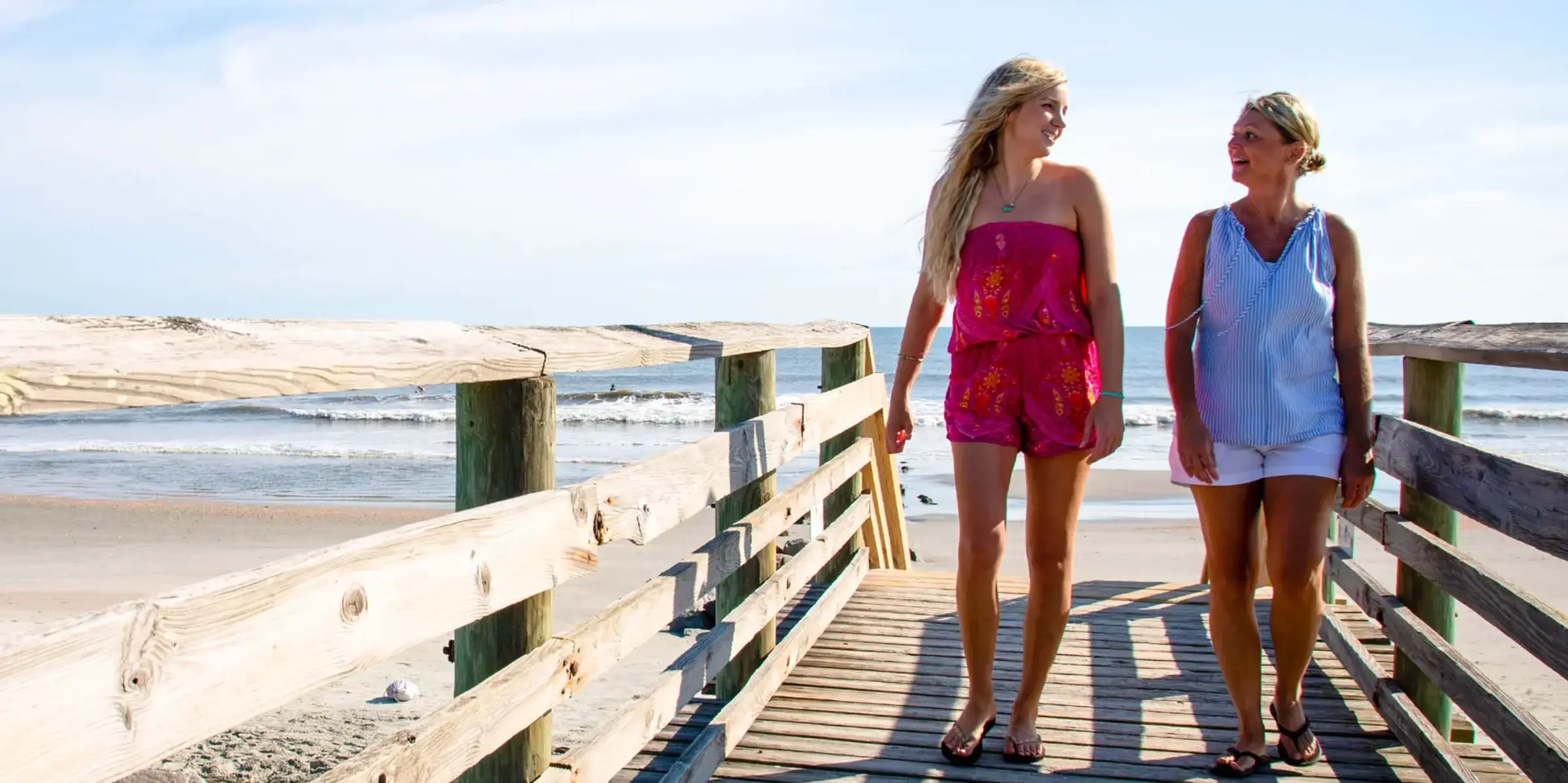 Two women walk on beach