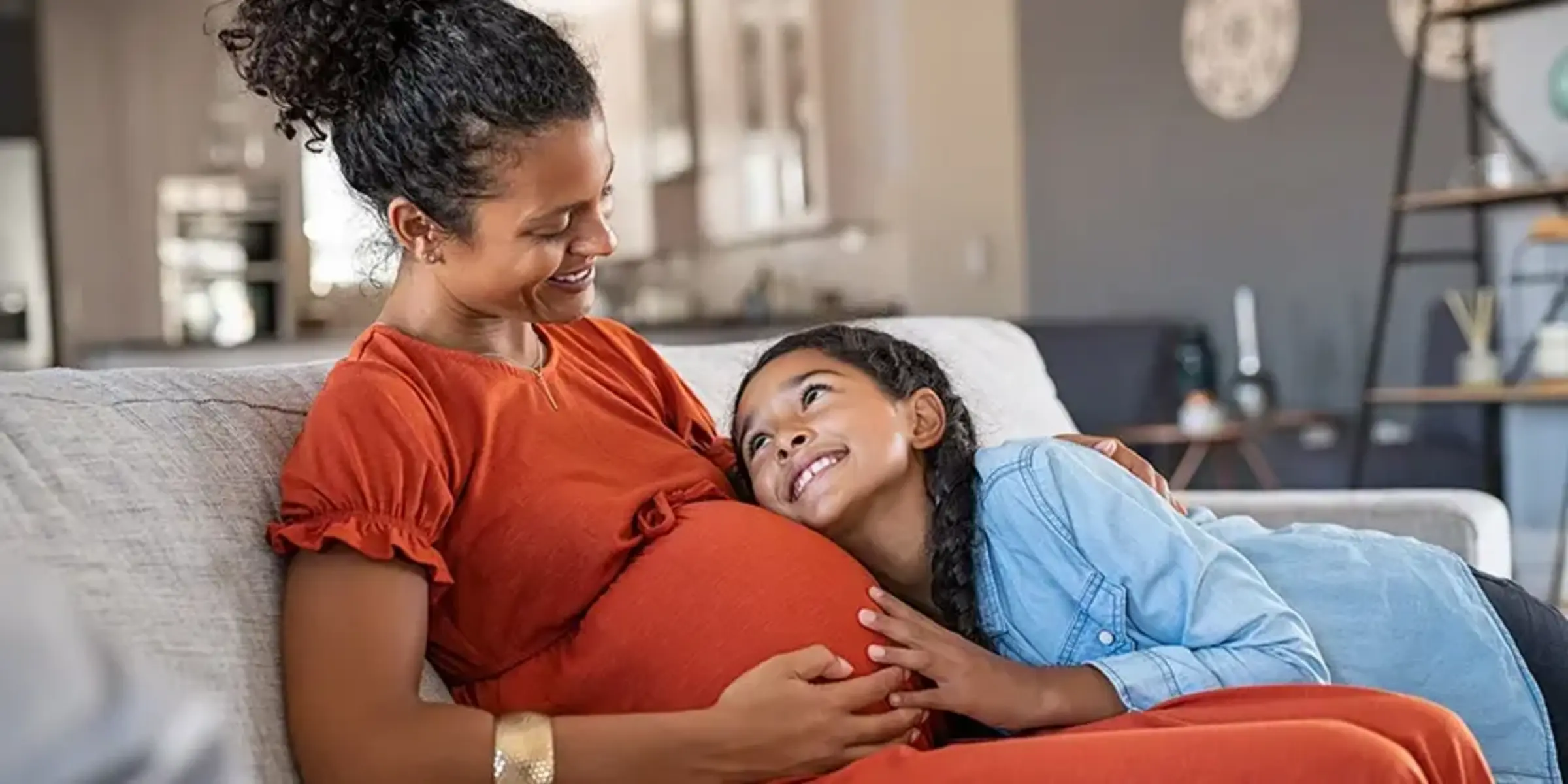 daughter hugging pregnant mother