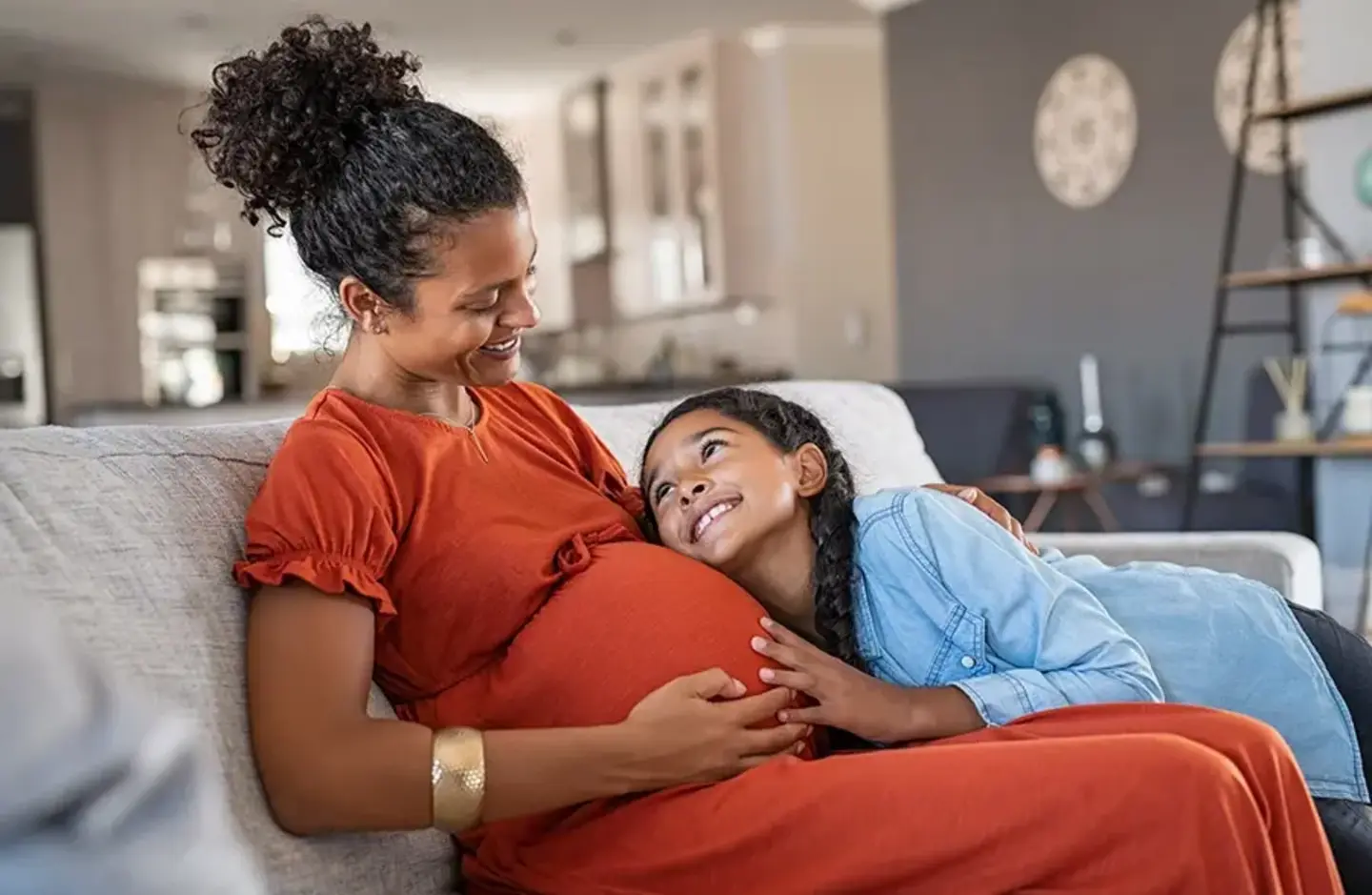 daughter hugging pregnant mother