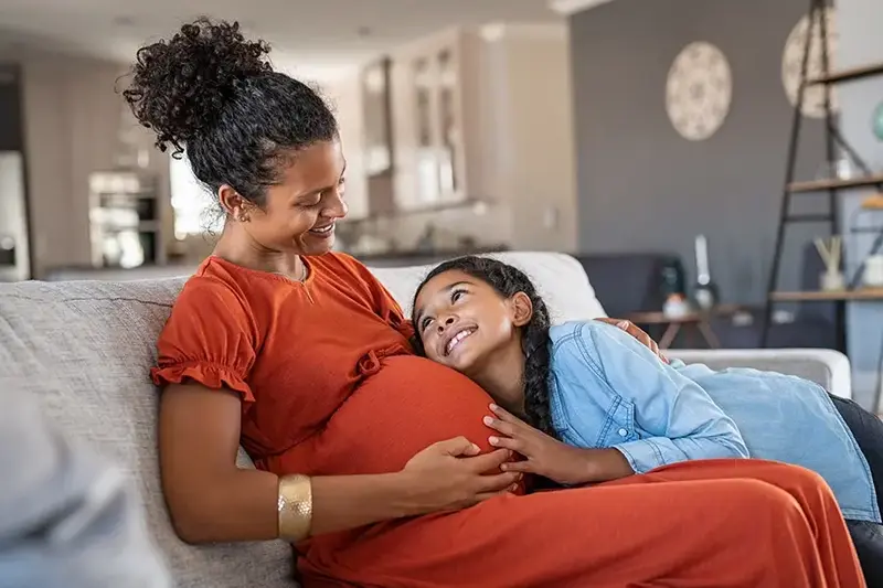 daughter hugging pregnant mother