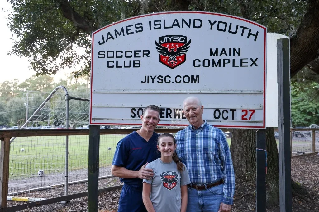 Czarniecki posing with Dr. Stuart and his daughter Sasha at the James Island Youth Soccer Club