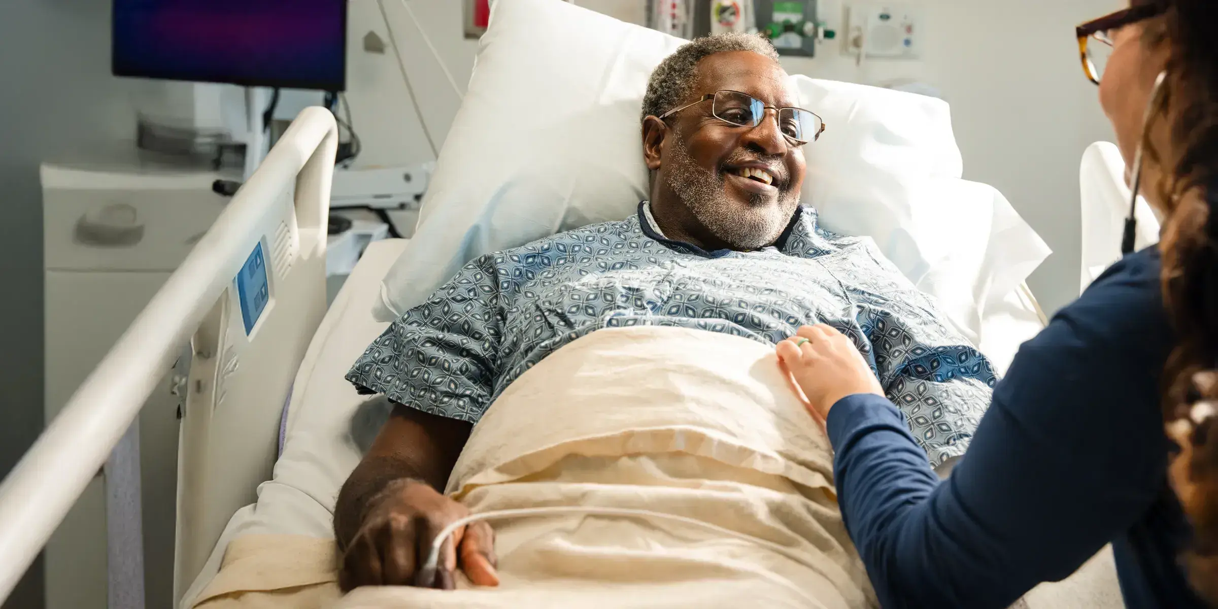 Man hospital bed smiling with nurse