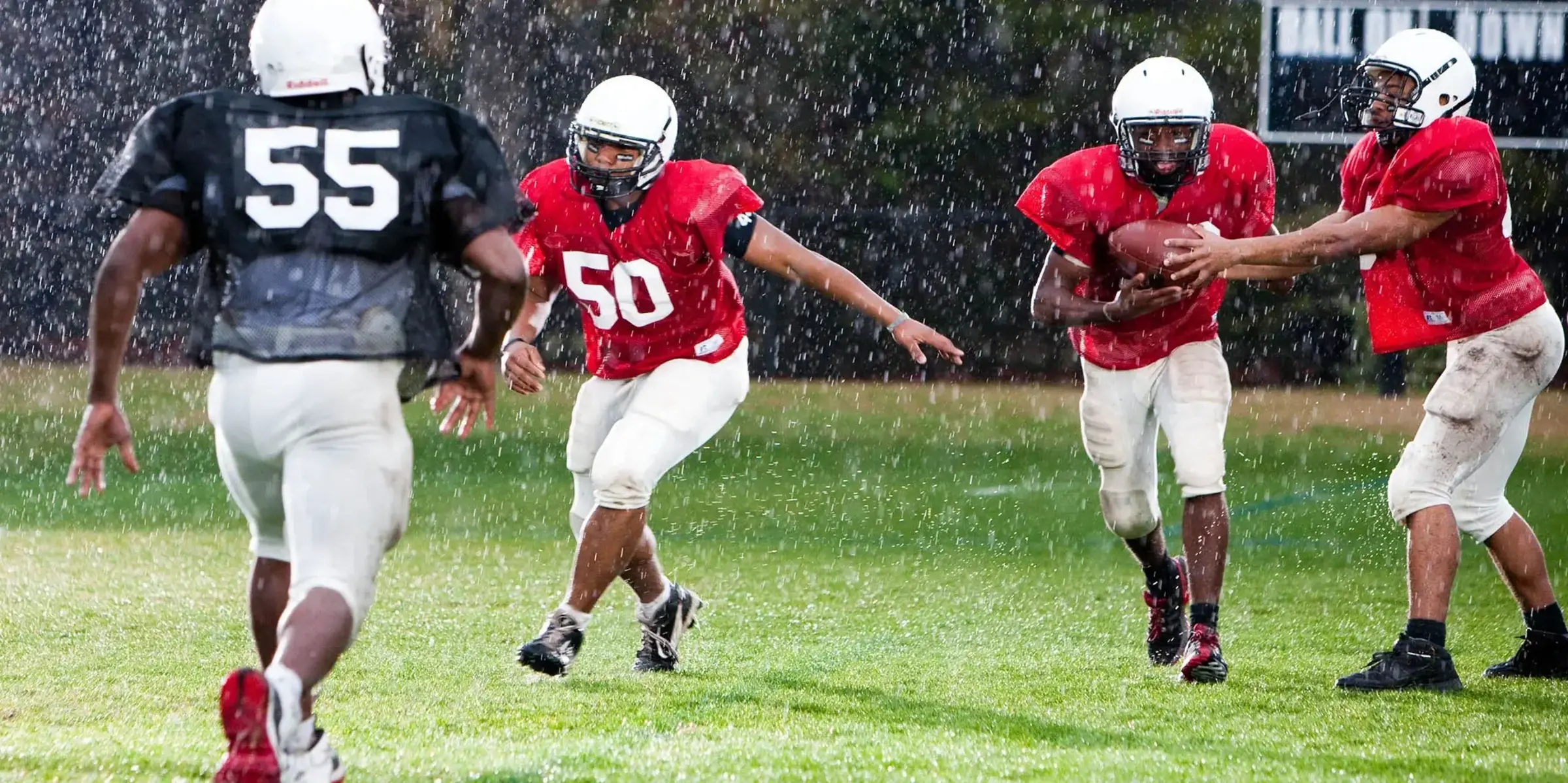 Kids play football in the rain