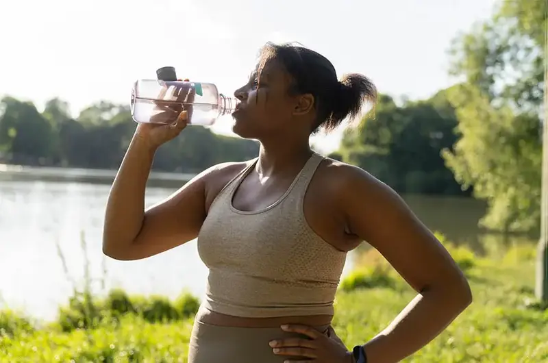 Young African American woman drinking water