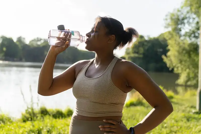 Young African American woman drinking water