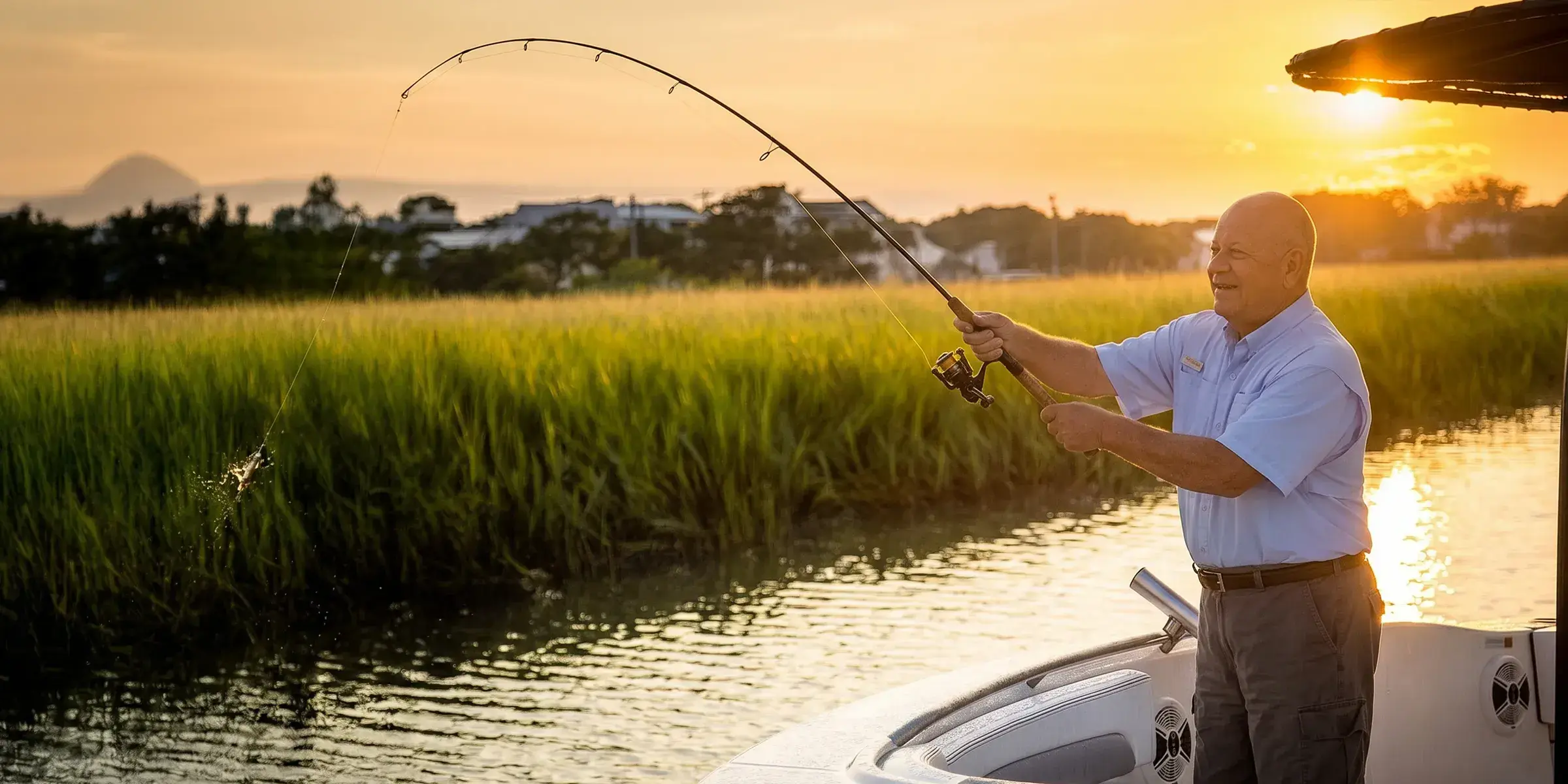 Older man catching fish on boat