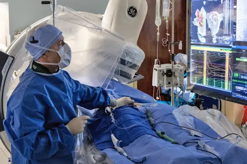 Doctor in scrubs monitoring heart equipment