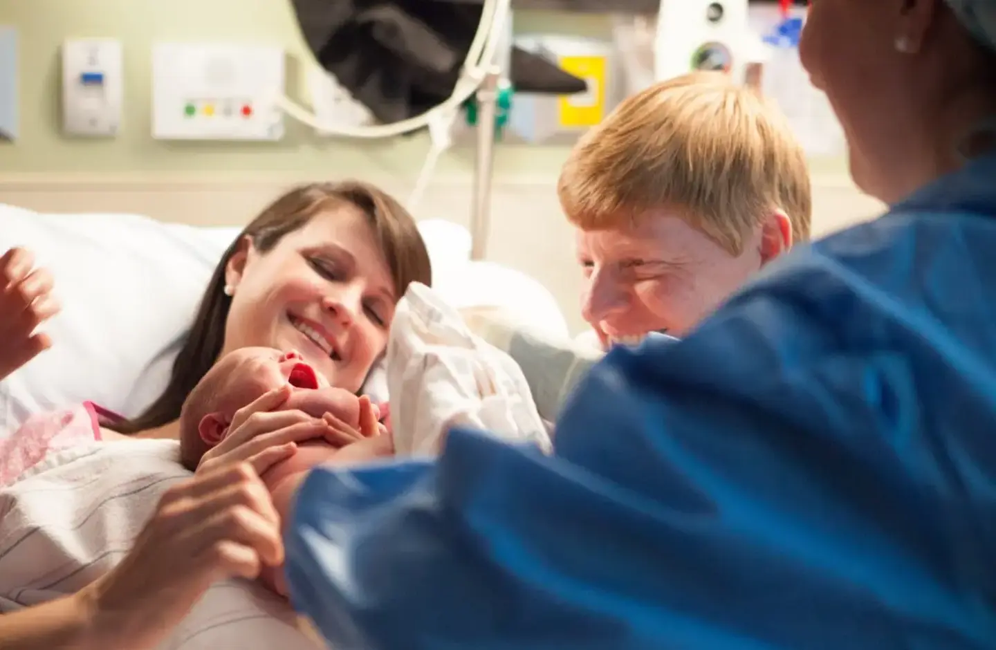 doctor hands baby to mom