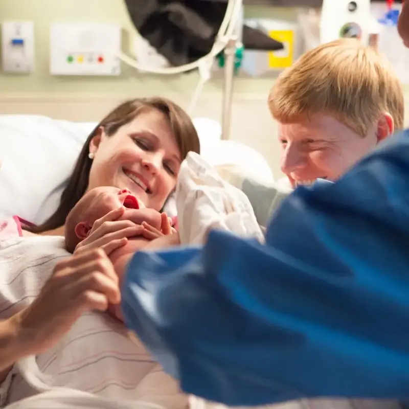 doctor hands baby to mom