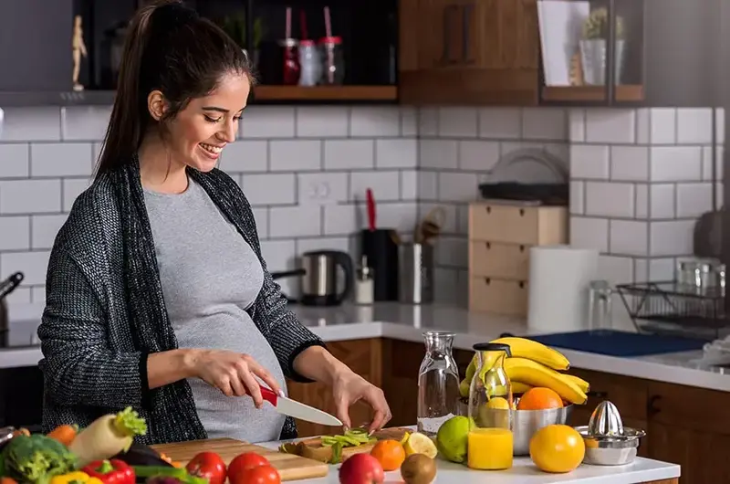 pregnant woman prepping meal