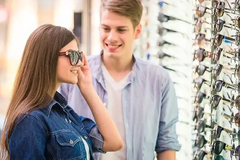 young couple looking at sunglasses