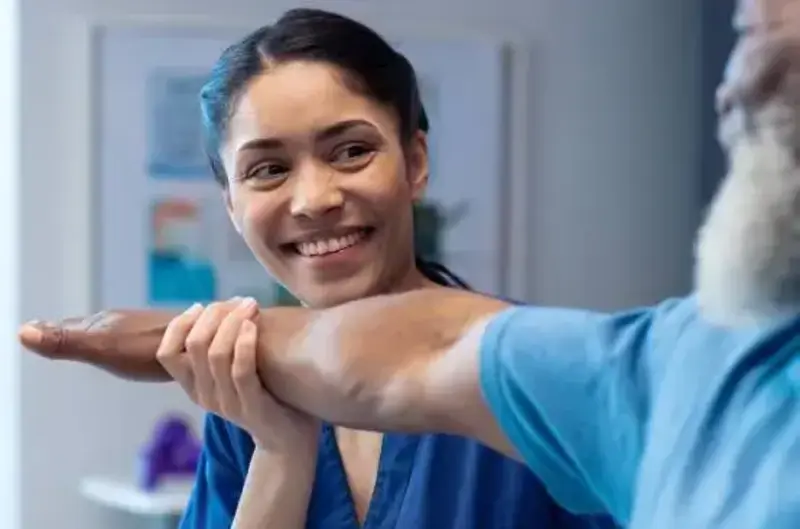 Physical therapist holds patient arm