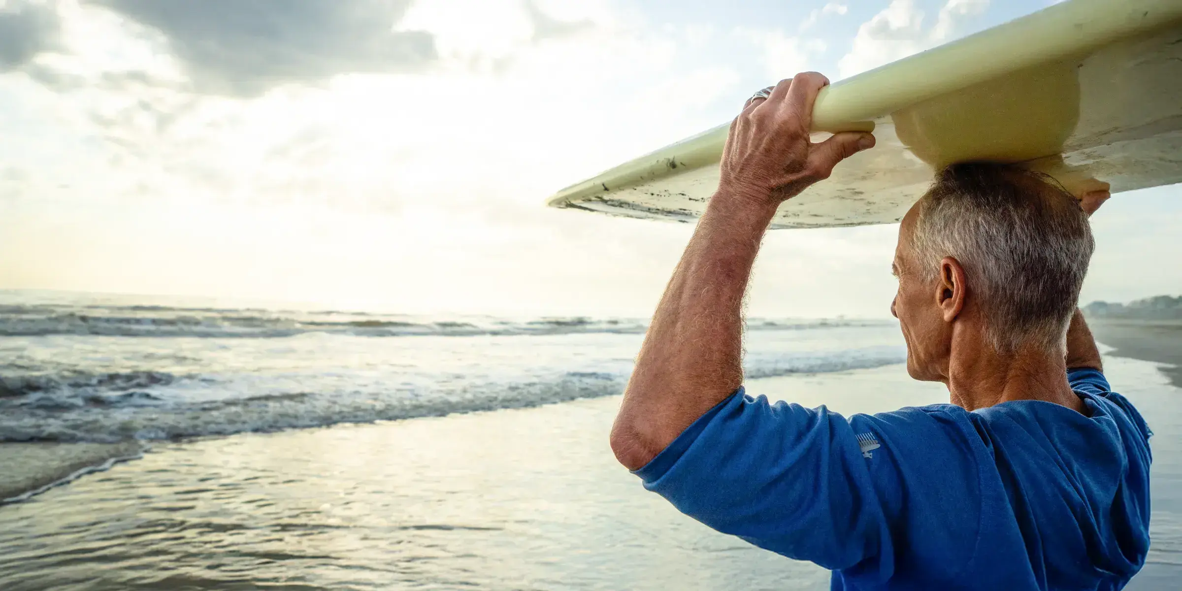 Older man surfboard on head