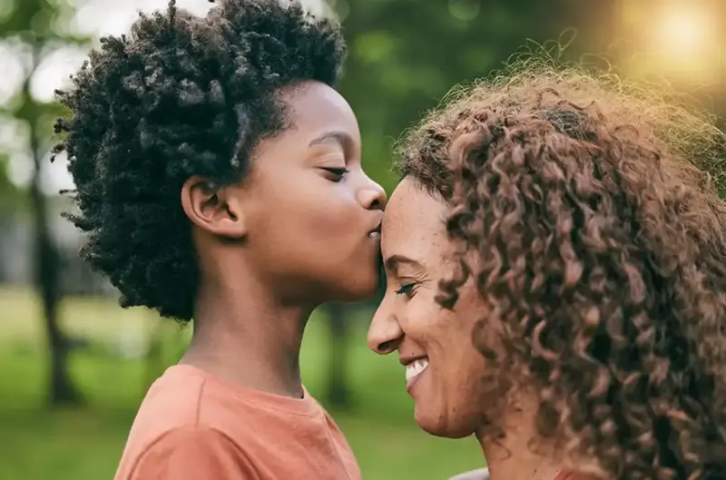 Son kissing a mother on the forehead