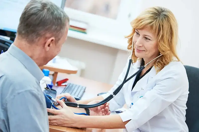 physician doctor is checking the blood pressure of the patient