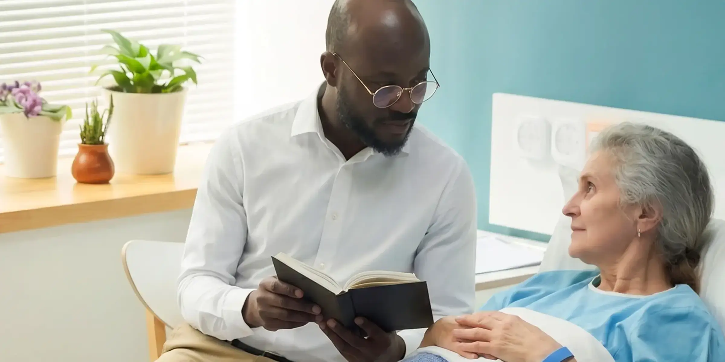 Pastor reads to patient in bed