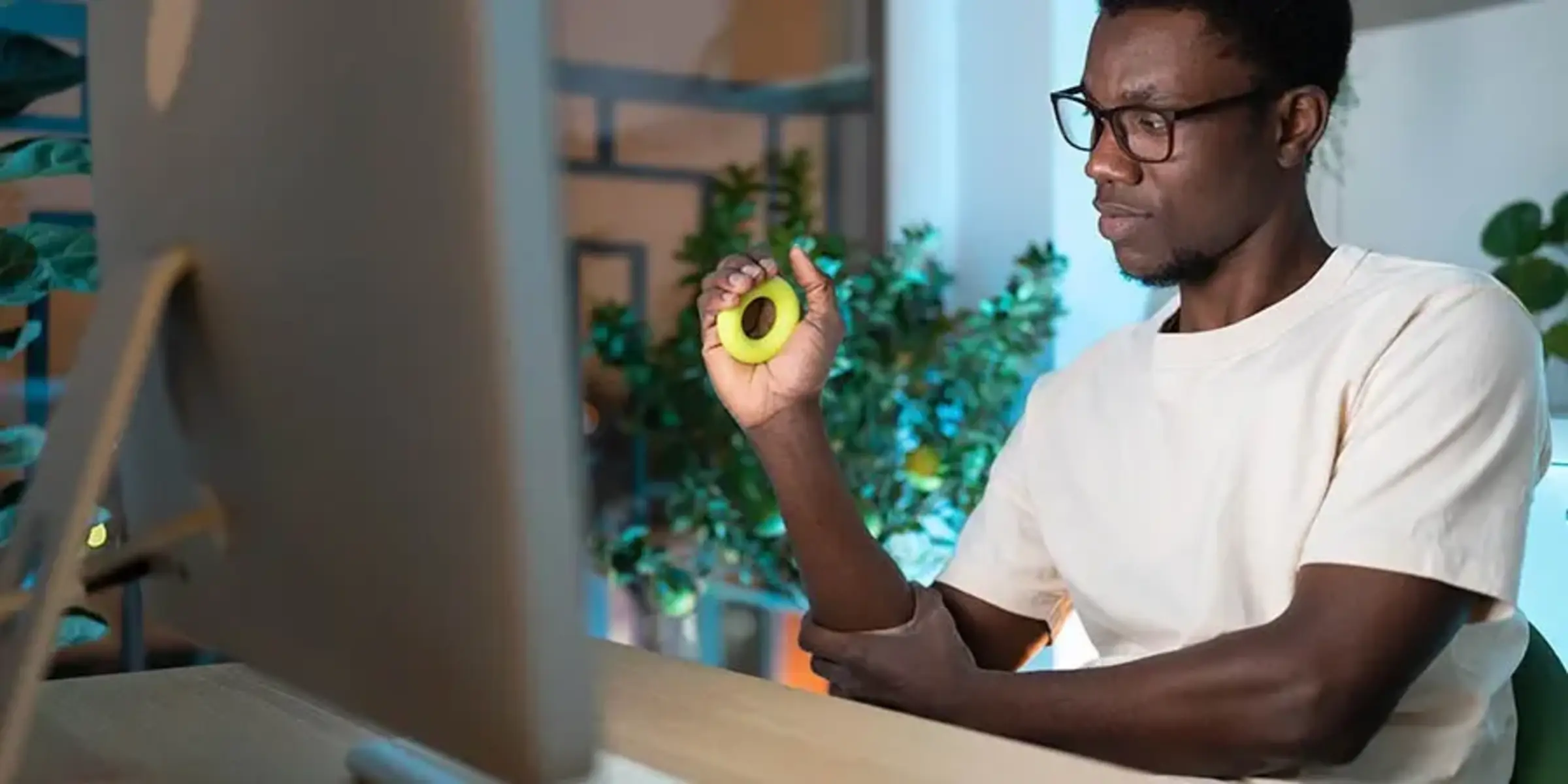 Young African man exercising with silicone grip ring doing hand exercises for Carpal tunnel syndrome prevention