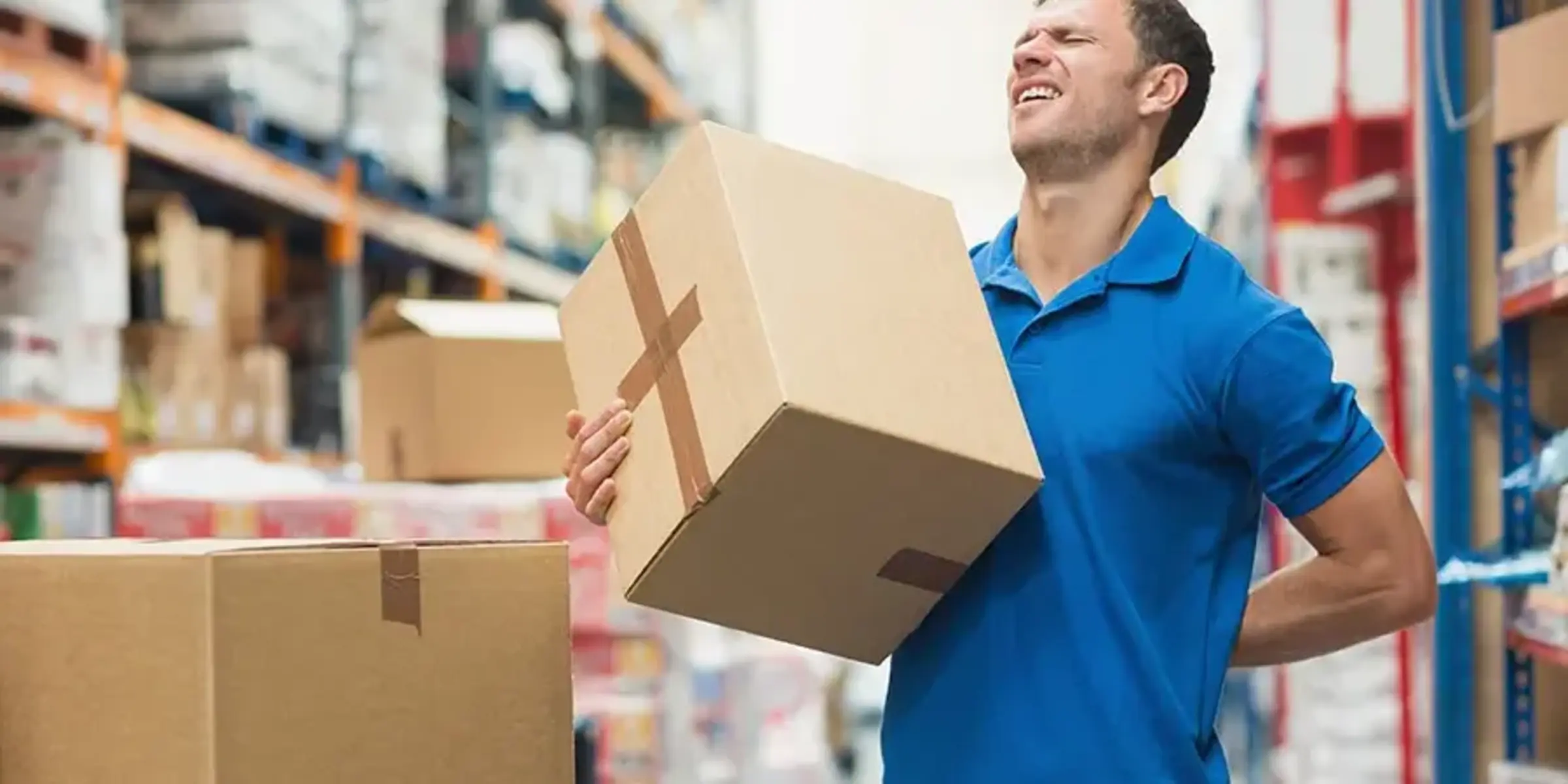 man with back pain while lifting a box