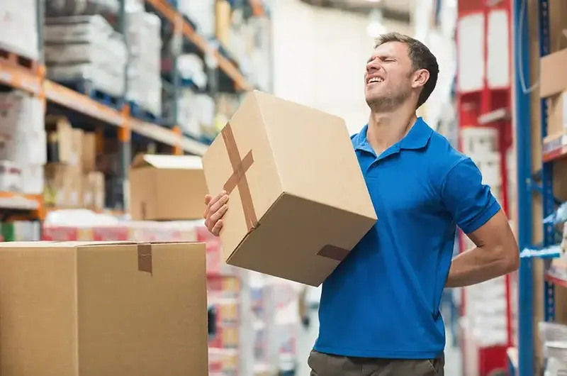 man with back pain while lifting a box