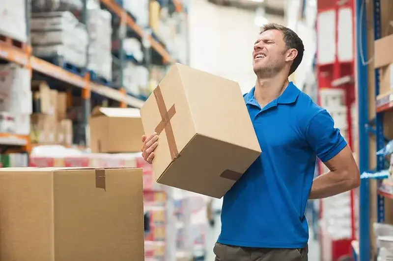 man with back pain while lifting a box