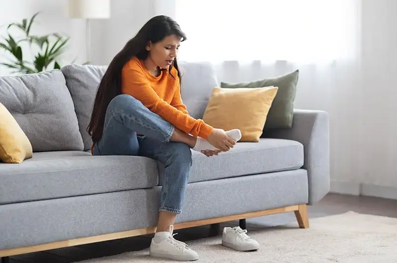 Young indian woman feeling foot pain due to bunion