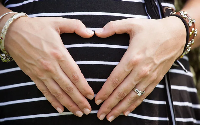 Heart hands on pregnant belly
