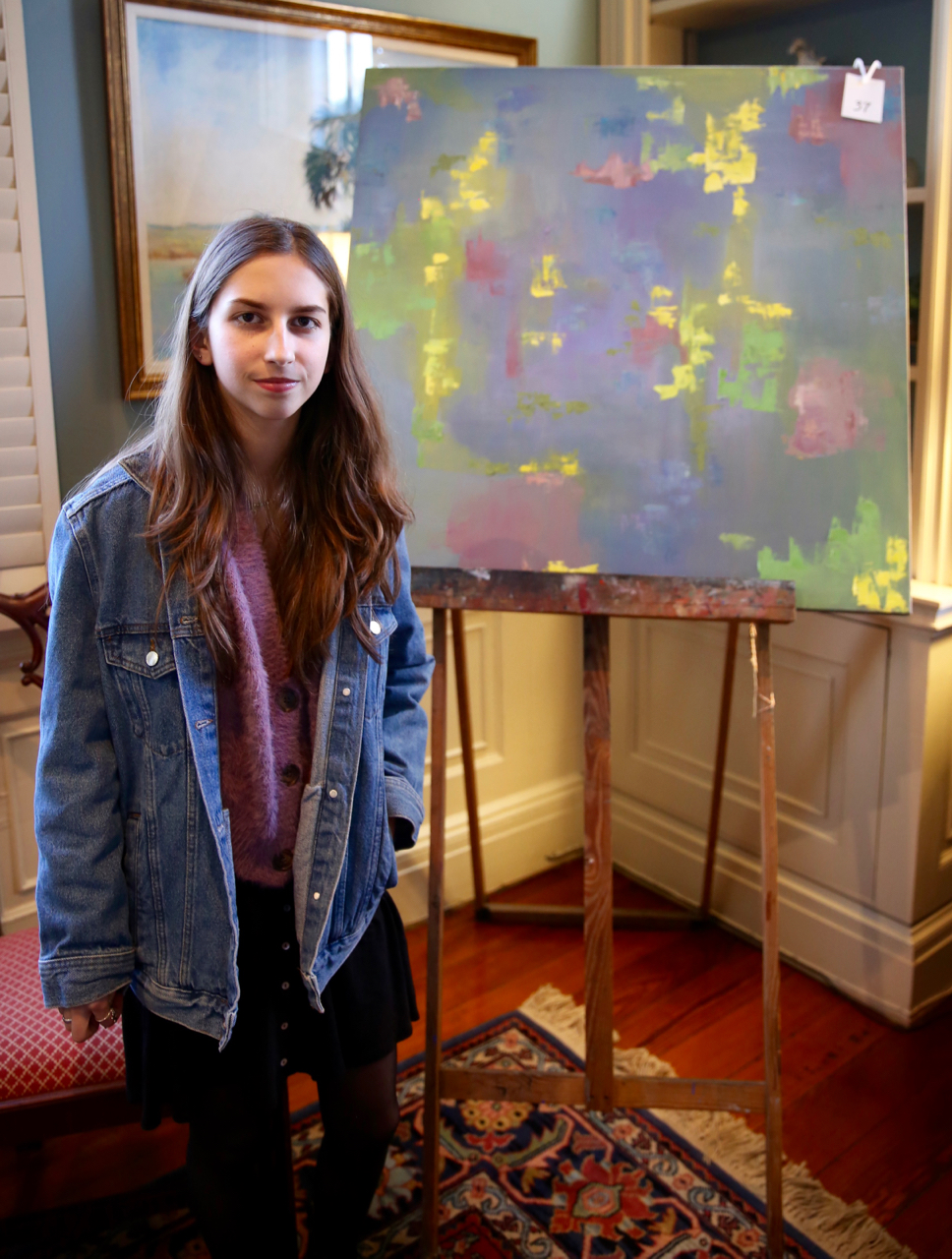 female student standing with artwork