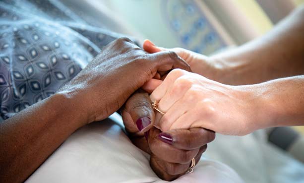 hospice nurse holding patient hand